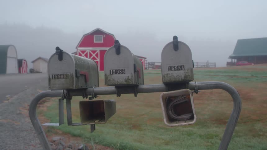 There are three mailboxes by this farm
