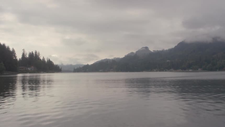Water flows in a large lake under cloudy skies