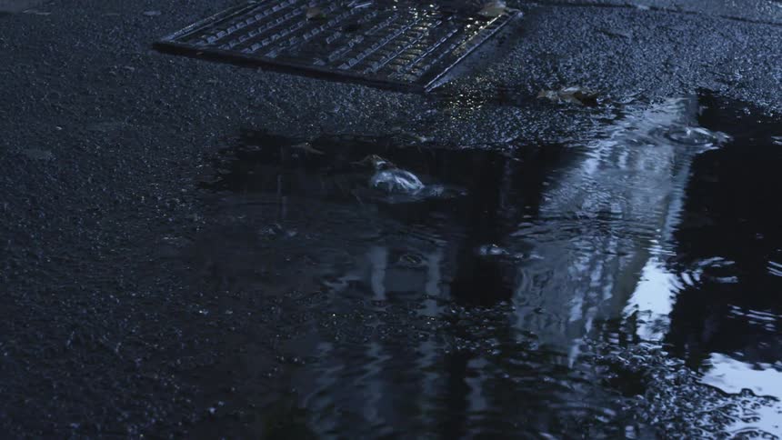 Raindrops falling on concrete