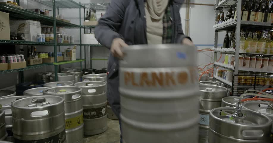 A woman moves a metal barrel