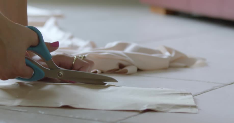 A woman cuts fabric with scissors