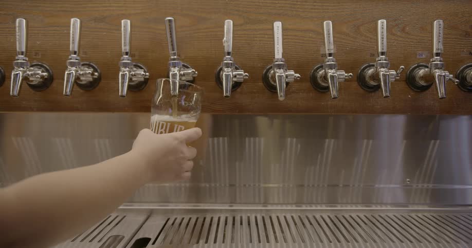 Beer is poured into a glass in a bar
