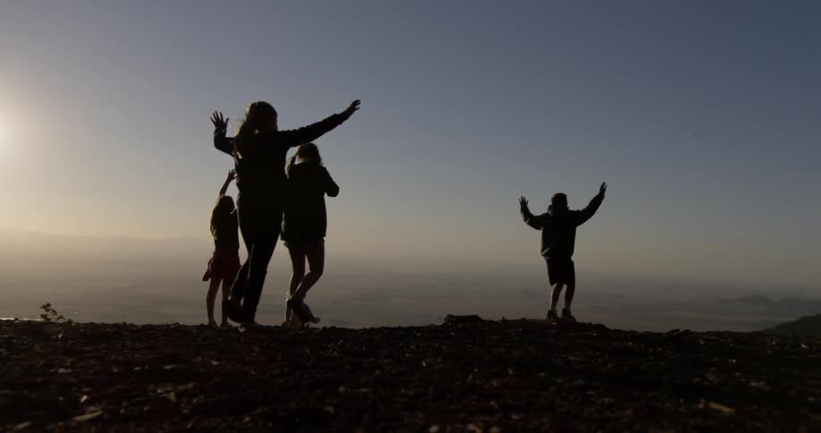 Children run playfully and wave from a top a mountain