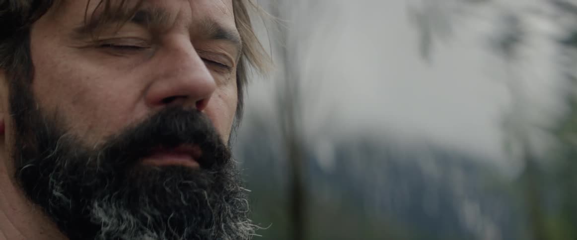 Man stands outside with his eyes closed