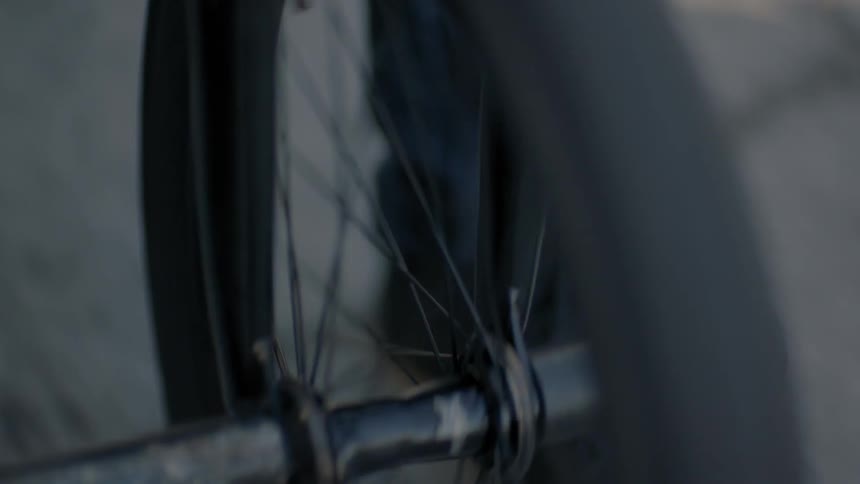 Bike spokes are rotating as someone rides a bike