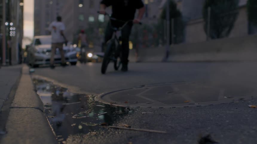 Bicyclist splashes in a puddle on a city street