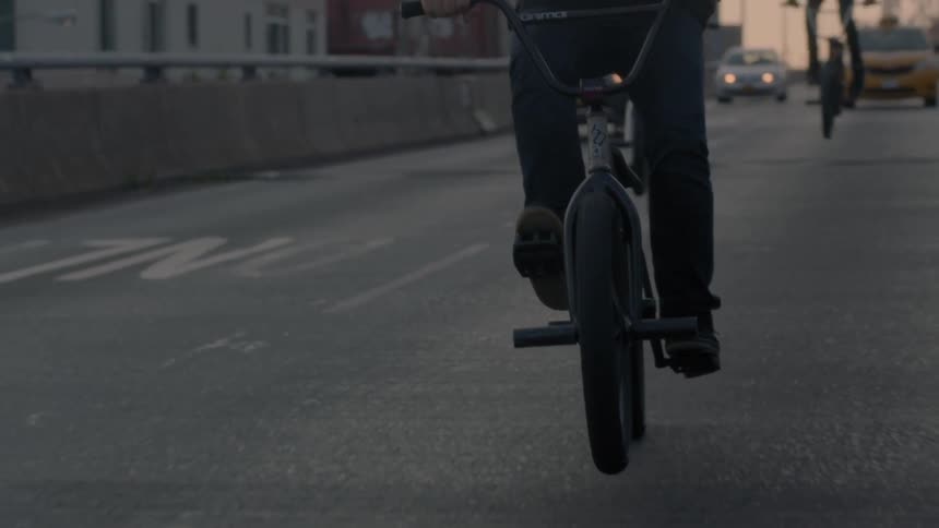 Bicyclists ride on a city street at sunset