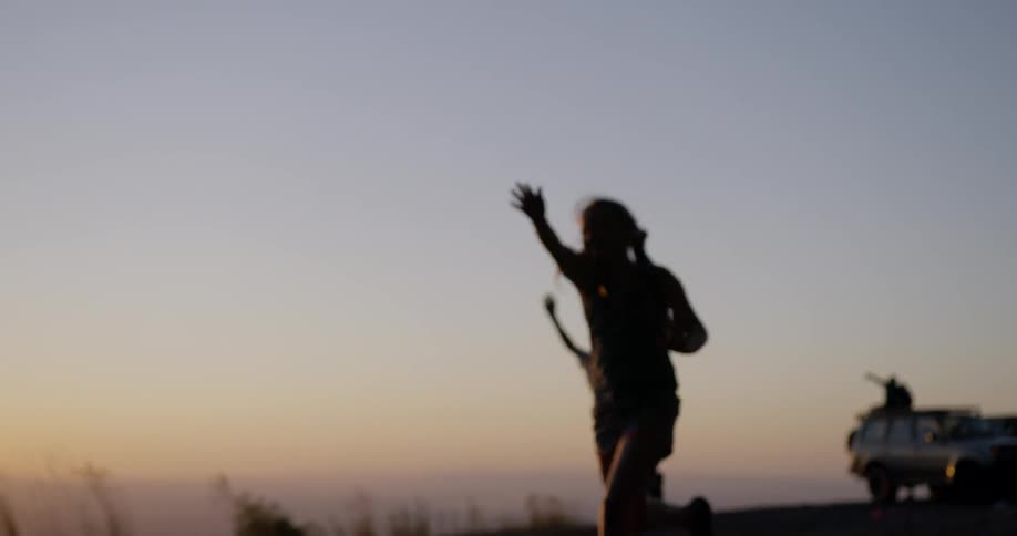 Three girls running away from a car