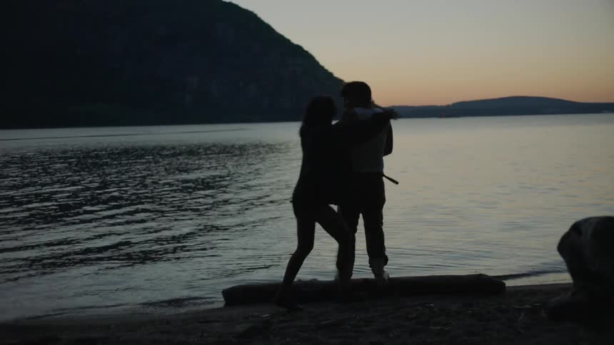 A couple playing at a lake shore