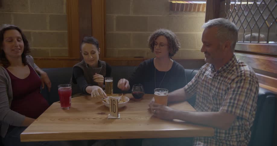 People drink beer and eat an appetizer in a restaurant