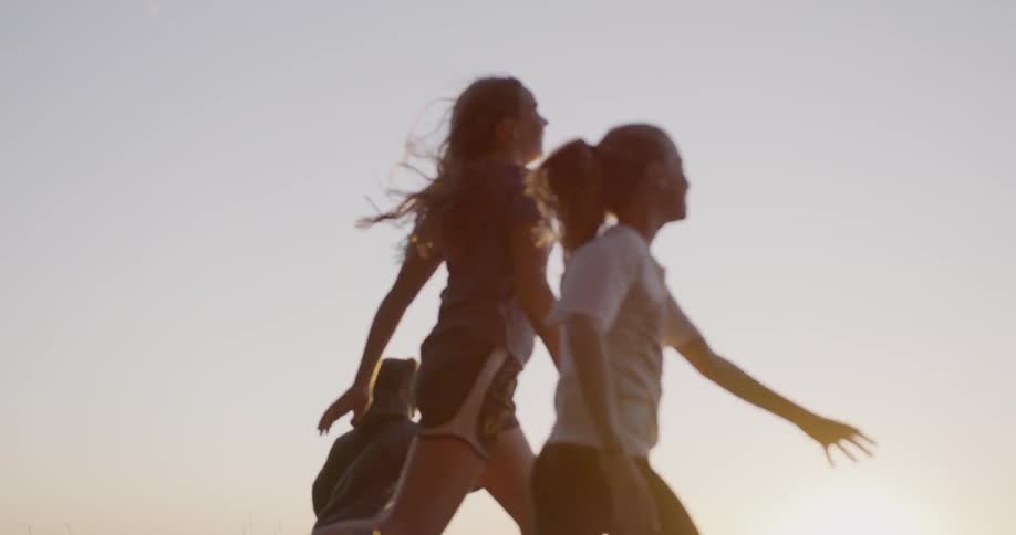Kids run near forest trees at sunset