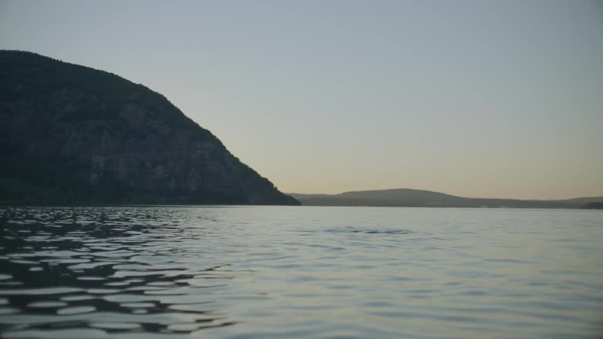 A man and woman in the water duck under then pop up