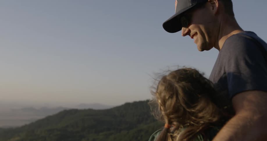 Father hugs his daughter on the top of a mountain