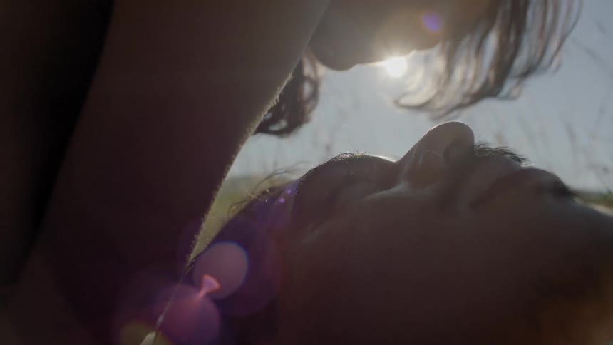 A woman kisses a man's face