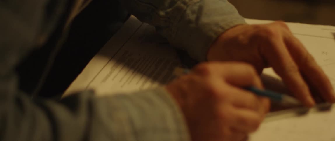 A man is making measurements and lines as he drafts a blueprint