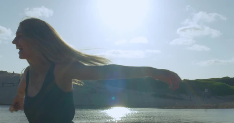 Woman twirling around outside on the beach