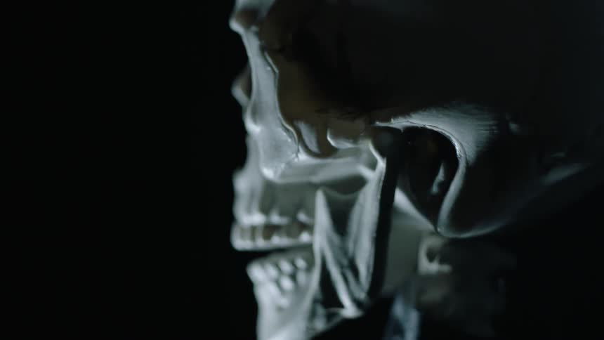 A skull is spinning in a dark room