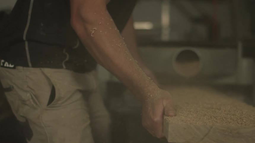Man sawing a large board