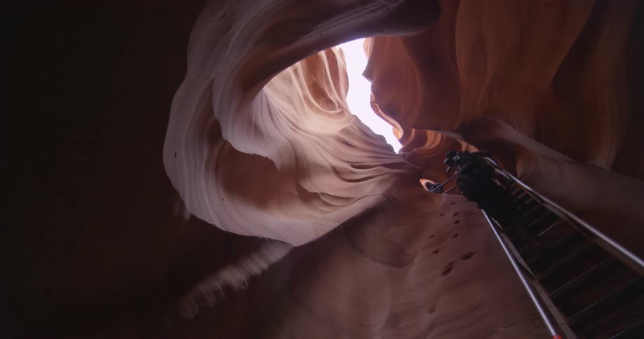 People climb up a ladder in a canyon
