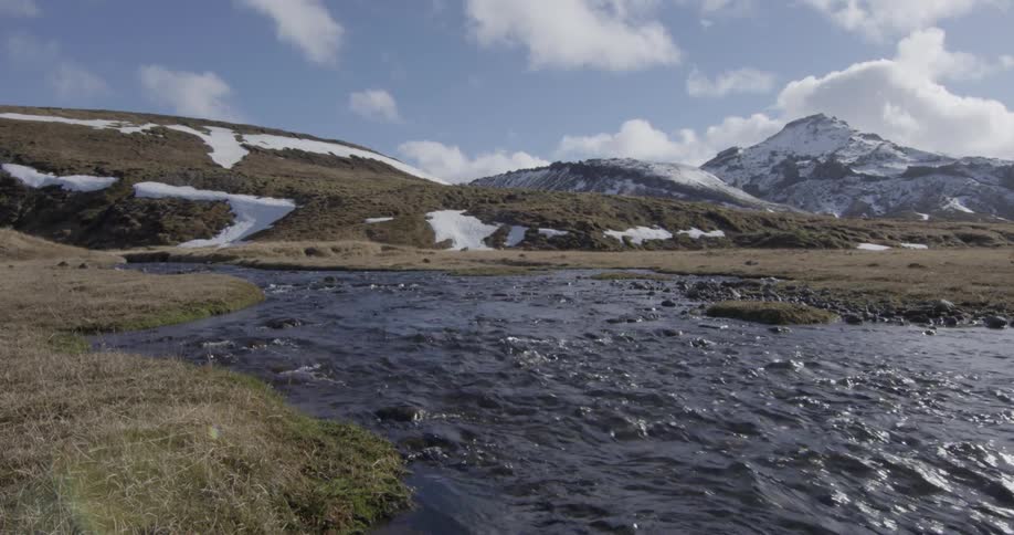 The small stream runs from the snow covered mountain