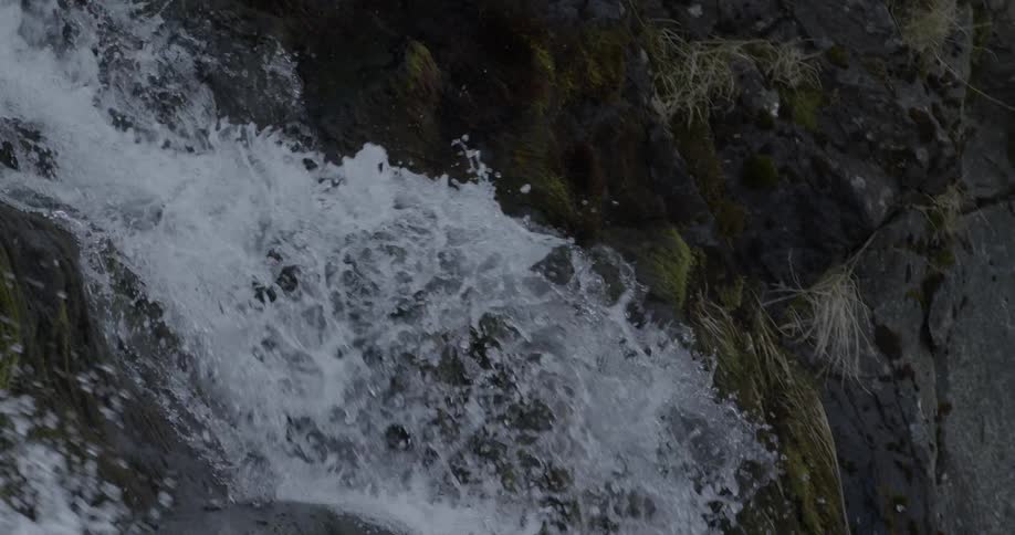 A large amount of water rapidly moving downhill and over some rocks