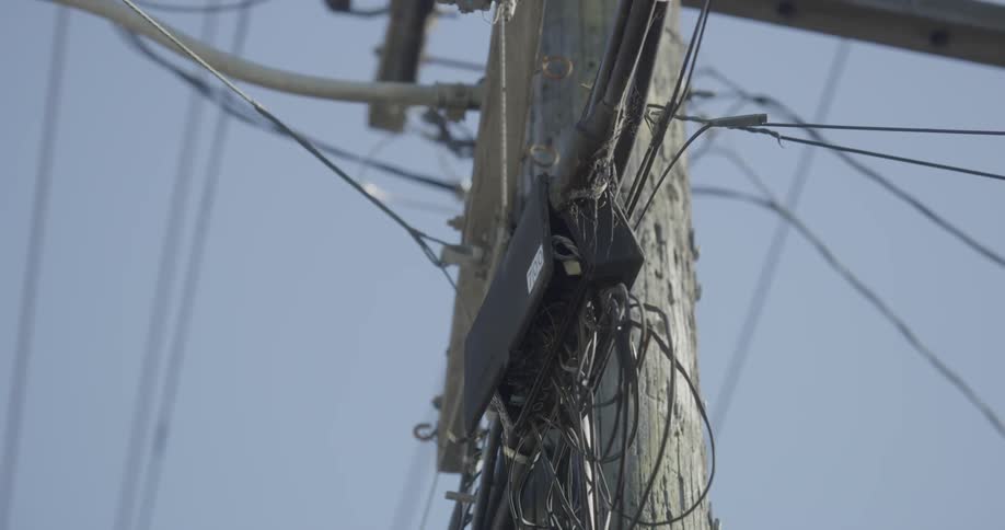 Cluttered city power lines on telephone pole
