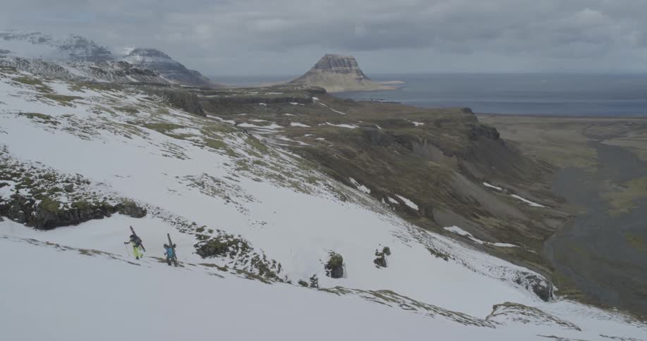 People are hiking up a snow covered mountain