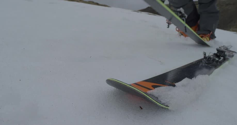 A skier drops a ski in the snow