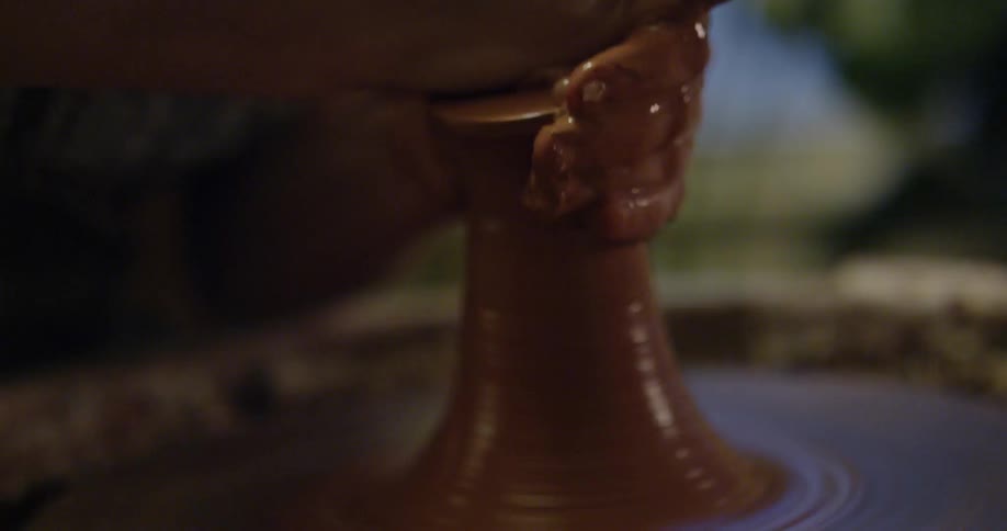 A woman making pottery in a close up view