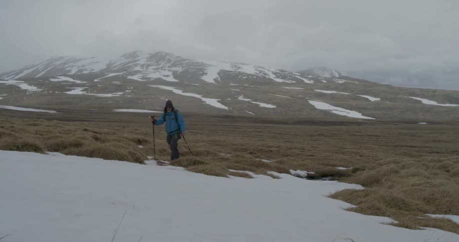 A  man cross country skis in the mountains