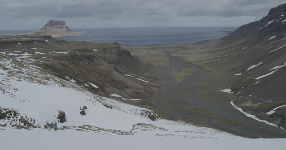People are walking up the side of a snow covered mountain