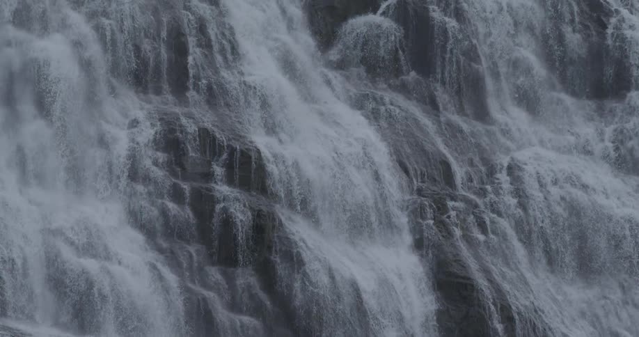 The wide waterfall is spraying water downhill