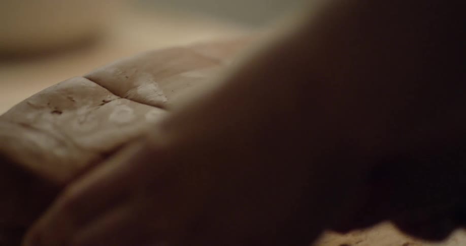 A woman is slicing a block of clay into equal portions