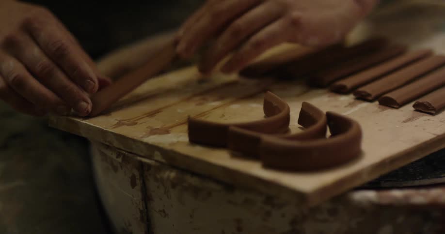 Person bends pieces of brown material into u shapes