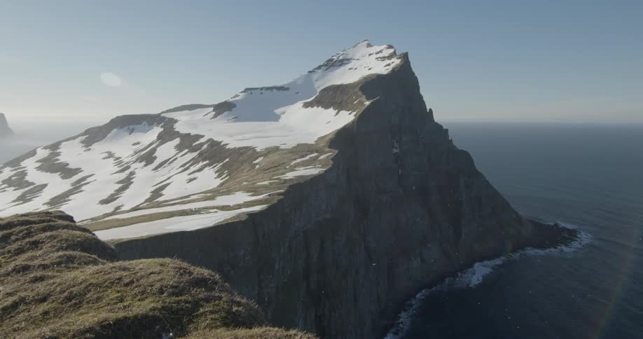 Snow covered mountains next to an ocean
