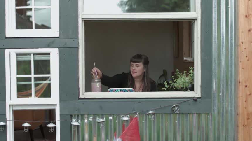 A woman is painting by the window