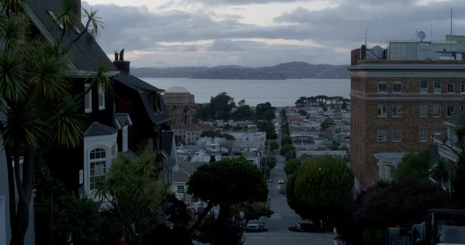 A hillside city street that leads down to the water's edge
