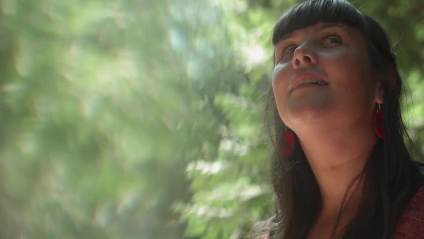 A woman is looking out over the dense forest