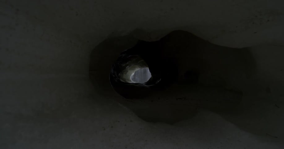 A view through an iceberg that shows waterfall at the end