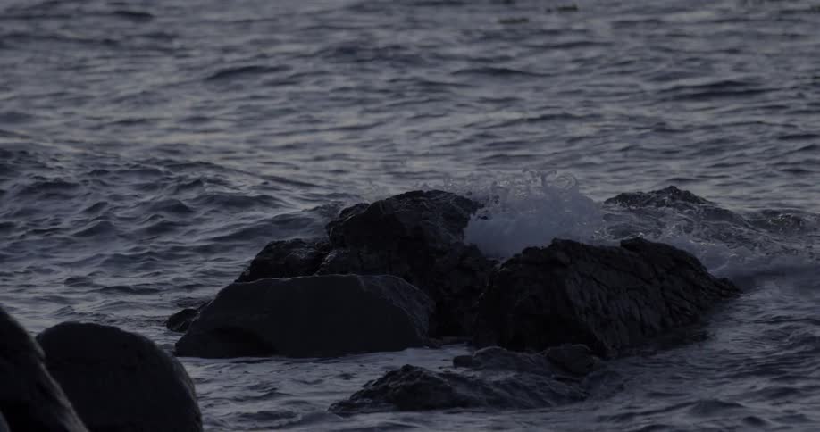 The rough waters crash against the rocks