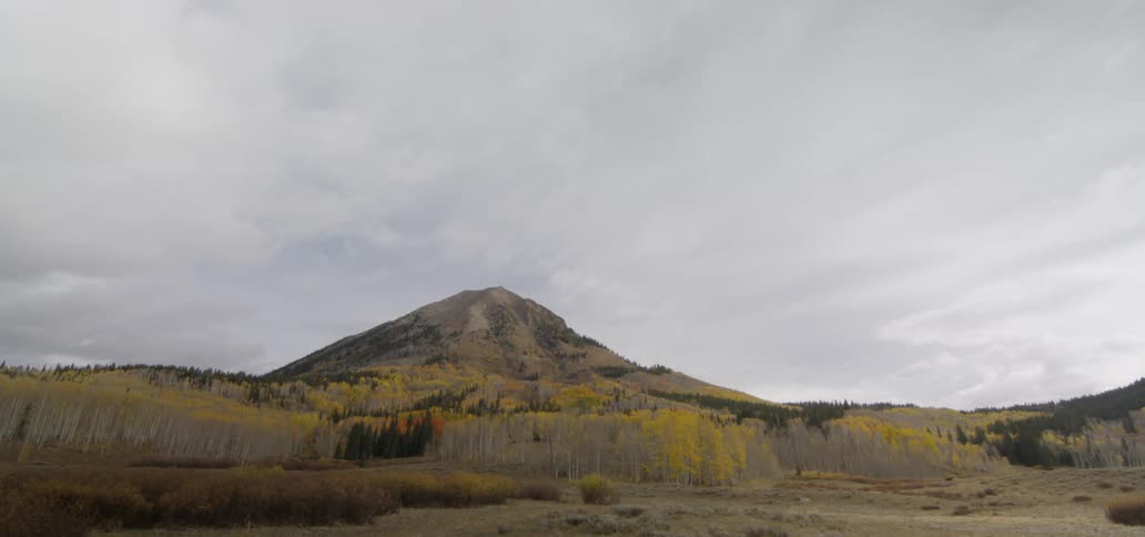 Clouds flowing over mountain and colorful forest trees in the fall