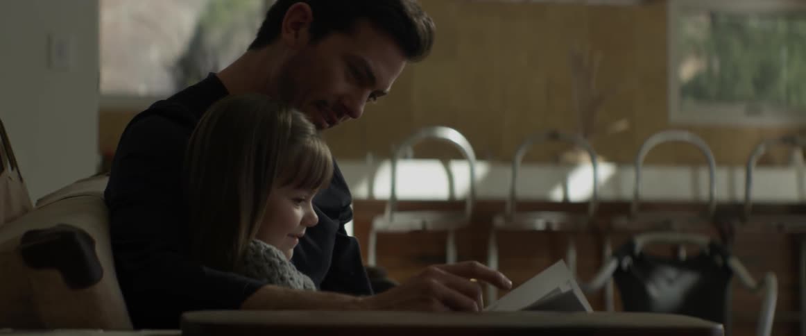 A man and child look at a book together