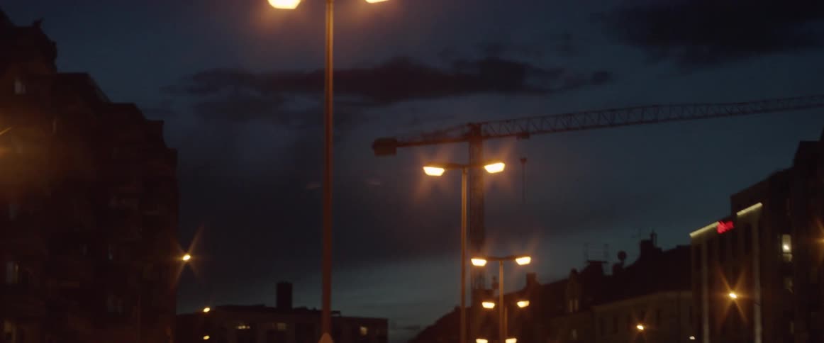 The road is lined with light posts at dawn