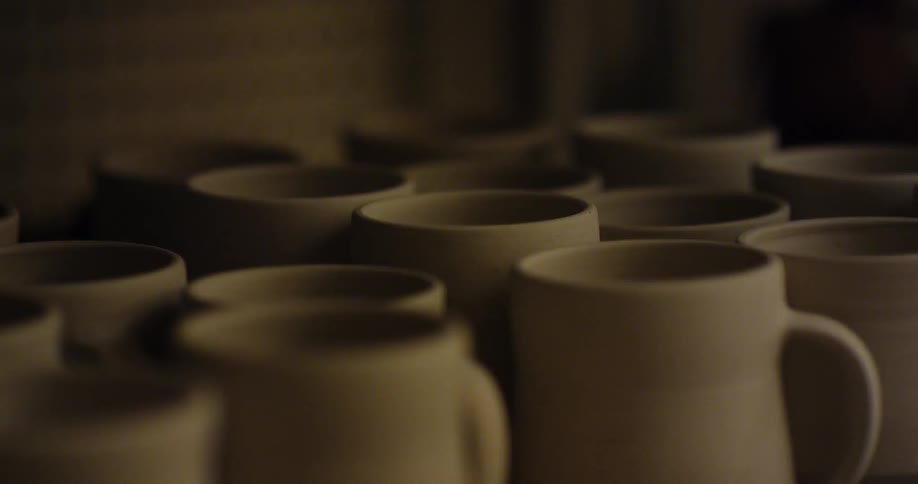 Pottery cups sit in rows after being created