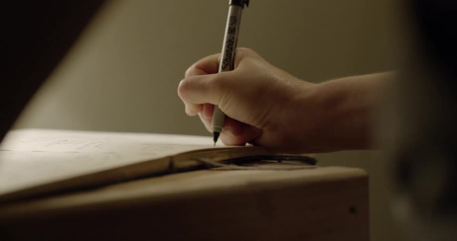 A person writes in a notebook