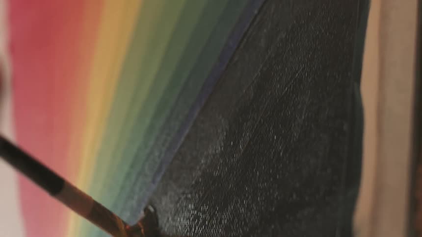 A painter is painting strokes on a canvas during the day