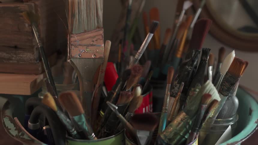 Paintbrushes sit in an art studio