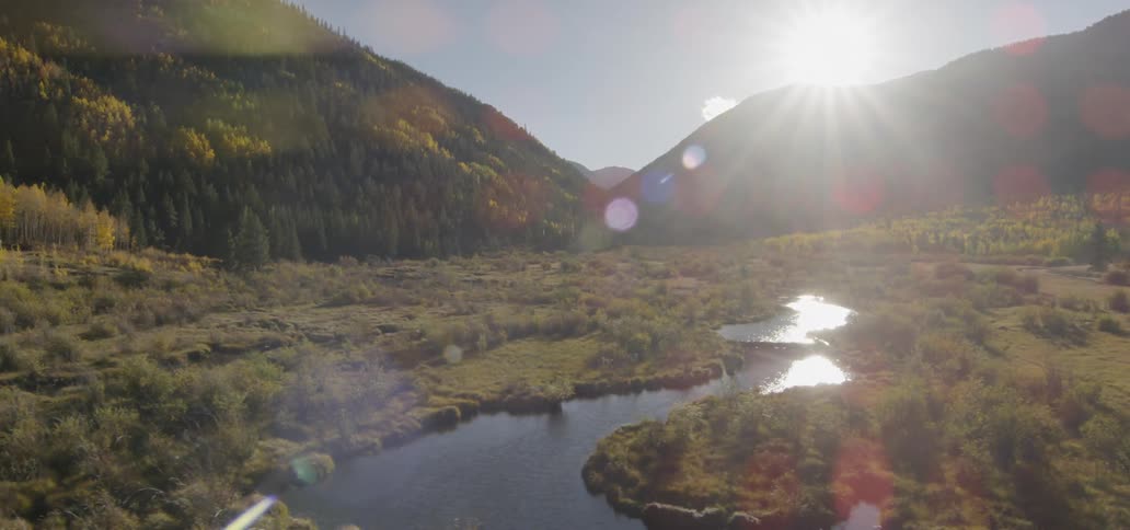 A river through forested mountains as the sun rises