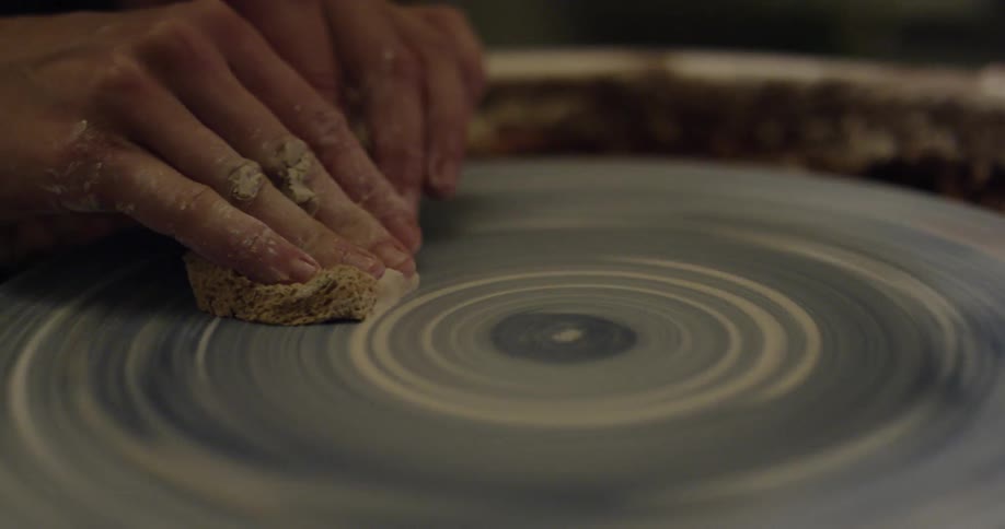 A person cleans a pottery wheel