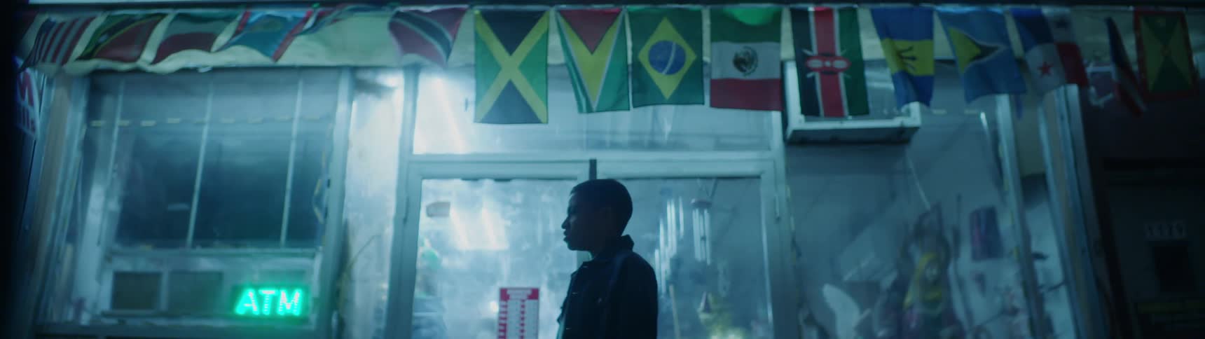 A banner of country flags flap in the wind above a man's head